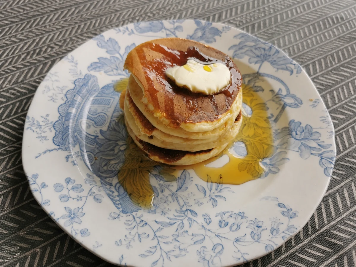 Stack of finished American pancakes with butter and syrup